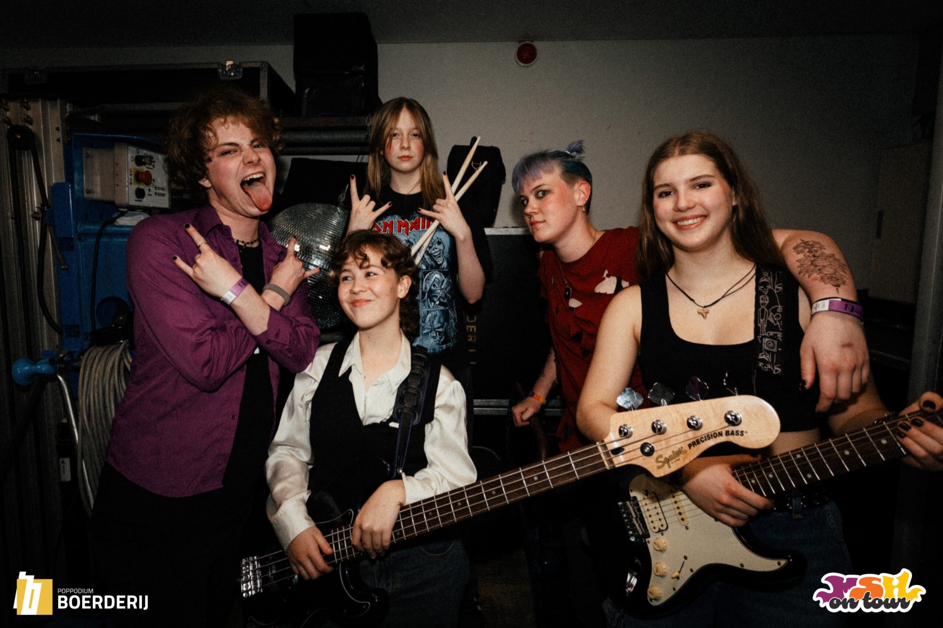 Jonge band van MusicSoulHouse poseert uitgelaten backstage met basgitaar